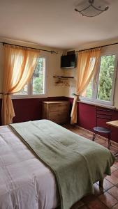 屈屈尼昂奥贝尔格拉塔博乐都库乐酒店的一间卧室设有一张大床和两个窗户。