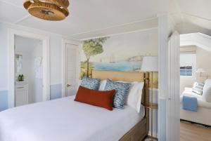 楠塔基特The Cottages & Lofts的卧室配有白色的床和墙上的绘画作品