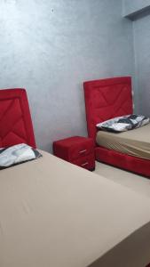 DerouaAppartement Mohammed V Airport Top的一间设有两张床和两张红色椅子的房间