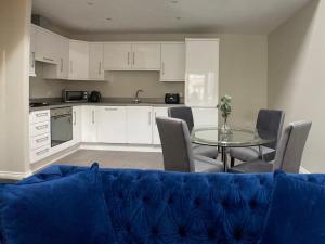 贝尔法斯特Edward St Apartments的客厅配有蓝色的沙发和桌子