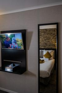 巴黎贝斯维斯特阿尔格鲁内申酒店的一张镜子,位于酒店带一张床的房间里