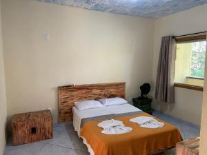 马卡科斯Pousada Casinha Velha的一间卧室配有带毛巾的床