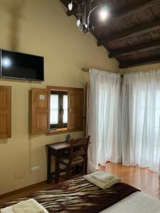 Santa MaríaCasa Milia的一间卧室配有一张床、一张桌子和一个窗户。