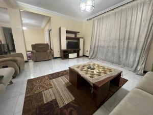开罗Cairo's Heart Central Apartment in Masr El Gedida的带沙发和咖啡桌的客厅