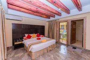 索拉哈七星酒店的一间卧室配有一张大床,提供红色和黄色枕头