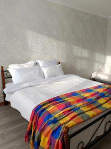 阿克托比12 Microragion Apartments的床上有五颜六色的毯子