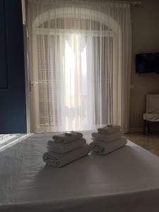 伊斯基亚Villa Antonietta Ischia的一堆毛巾坐在床上,靠窗