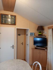 拉波勒mobil home camping *** les ollivaud的小房间设有电视和门