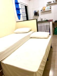 阿布拉奥Casa Pitanga - Abraão - Ilha Grande的配有2张床的带白色床单和枕头的客房