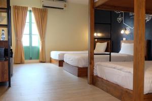 曼谷Siri Poshtel Bangkok的一间卧室设有两张床和大窗户