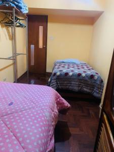 库斯科Ukumari Hostel的客房设有两张床和一张双层床。