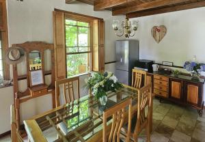 罗森维尔Rawsonville House的厨房配有玻璃桌、椅子和冰箱