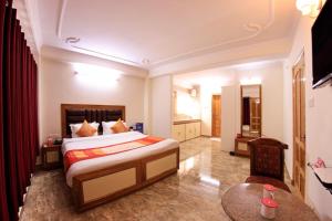 西姆拉Goroomgo Kalra Regency - Best Hotel Near Mall Road with Parking Facilities - Luxury Room Mountain View的酒店客房配有一张床铺和一张桌子。