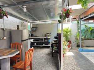 福尔图纳Cabinas Las Palmas del Sol的厨房配有冰箱和桌子,还有一些植物