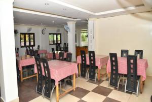布莱尔港Hotel Sea Rock Porte Blair的用餐室配有粉色和黑色的桌椅