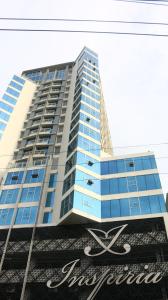 达沃市Triann Condo Staycation Davao in Inspiria Condominium Building的一座高大的蓝色建筑,前面有标志