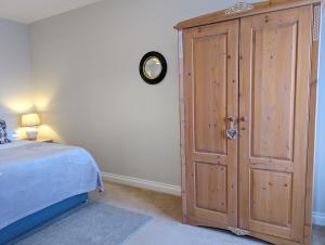 PotterneLittle Chilsbury的一间卧室配有一张位于床边的大型木制橱柜