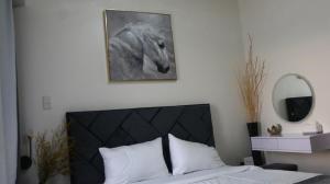 达沃市Triann Condo Staycation Davao in Inspiria Condominium Building的卧室墙上挂着一幅马的照片