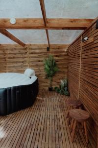 特鲁瓦Le Chalet Tipi avec jacuzzi et jardin的木甲板上配有床和椅子的房间