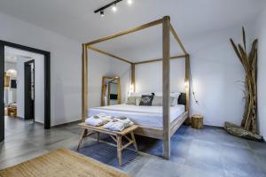 斯科派洛斯Casa Naturale的一间卧室配有一张天蓬床,在长凳上配有毛巾