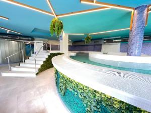 菲尼斯特雷Hotel Spa Playa Langosteira by Adeloló的一座带水族馆的建筑中的游泳池
