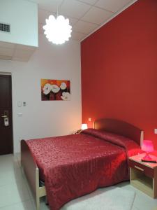 波波利阿尔伯格玛瑞旅馆 的一间卧室配有一张红色墙壁的床