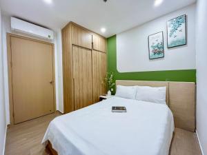头顿The Song Boutique Vung Tau的一间卧室配有一张白色的床和绿色的墙壁