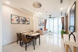 胡志明市ANGIA Luxury Apartment inside Landmark 81 Tower的用餐室以及带桌椅的起居室。