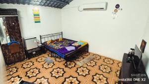 KharakvaslaBougain Villa- Sinhgad fort -Bedroom- Garden- Kitchen- AC- Wi-Fi-Parking-Khadakwasala Pune的一间卧室配有一张床,铺有木地板