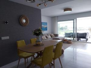 索托格兰德SOTOGRANDE Hoyo 10的客厅配有桌子和黄色椅子