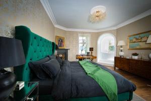 威廉堡Ardrhu House Fort William - Serviced Luxury Scots Baronial Country House的一间卧室配有一张大床和绿色床头板