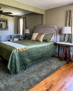 韦恩斯维尔Appalachian Farmhouse- A Homestead Experience的一间卧室配有一张带绿色棉被的床