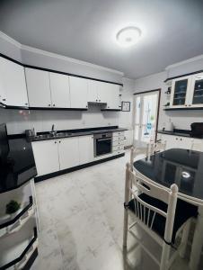 蓬特克苏斯Piso Pauser的厨房配有白色橱柜和桌子