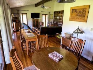 韦恩斯维尔Appalachian Farmhouse- A Homestead Experience的用餐室以及带桌椅的起居室。