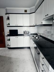 蓬特克苏斯Piso Pauser的白色的厨房配有白色橱柜和水槽