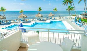 伊斯拉莫拉达Caloosa Cove Resort - With Full Kitchens的一个带游泳池和海洋的阳台