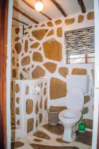 迪亚尼海滩Kijani Cottages - In Diani的浴室设有石墙和卫生间