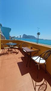 拉利内阿-德拉康塞普西翁Gibraltar Views Guest House的阳台上配有两张桌子和椅子,享有海景