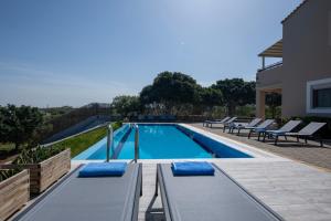 古瓦伊Four Seasons private villa - seaview - big heated pool - gym - sport activities的一座房子里带蓝色靠垫的游泳池