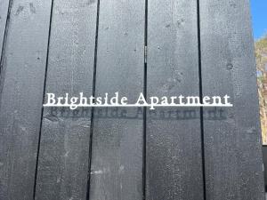 克里斯蒂安桑Brightside Apartment的黑色建筑的边边的标志
