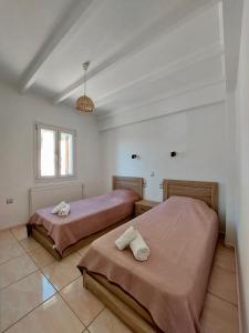 LévkiVilla Tramonto的白色客房的两张床,设有窗户