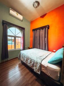 弗洛勒斯Casa Sunset的一间卧室配有一张橙色墙壁的床