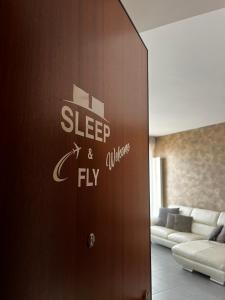 贝加莫SLEEP & FLY Bergamo Centro的有一扇门,上面标有睡眠和飞翔的标志