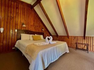 Alto del RobleHotel El Tirol的一间卧室配有一张天鹅床