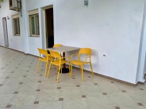 萨兰达Duka Apts的一张桌子,旁边是黄色椅子
