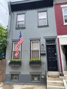 费城Modern South Philly Townhome的一座灰色的房子,上面有美国国旗