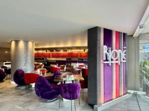 昆卡利奥尼精品酒店的大堂内的餐厅,配有紫色椅子和桌子