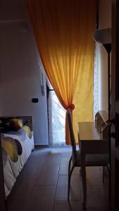 福贾克隆那住宿加早餐旅馆的一间卧室配有一张床、一张书桌和一个窗户。