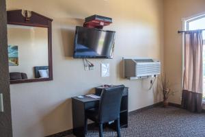 Williamsport Grandview Hotel的客房设有书桌和墙上的电视。