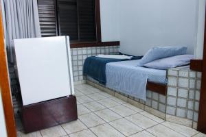 乌巴图巴Hotel São Charbel的一间卧室配有一张床,旁边设有白色的板